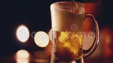 啤酒从瓶子里倒入玻璃。 一杯啤酒放在桌子上，在酒吧或酒吧的玻璃上有<strong>凝结</strong>水
