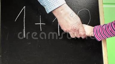 男人帮助孩子把数字写在黑板上