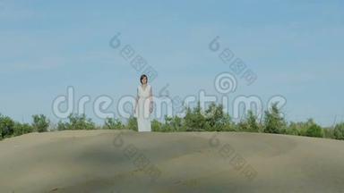 穿着白色衣服的女人在沙丘上散步