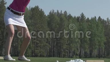 年轻女子高尔夫球手在绿色球杆上训练。 女孩踢球