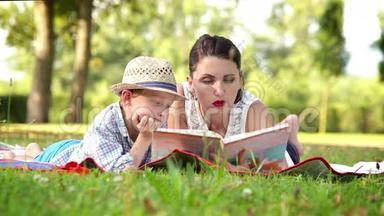 妈妈在公园野餐时给儿子读了一<strong>本书</strong>