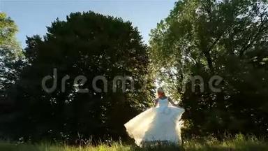 美丽浪漫时尚的金发新娘，穿着白色连衣裙，在梦幻般的夕阳下在森林里跳舞