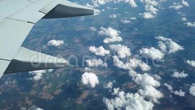 从云层和地面上的飞机的窗口观看，在云层上方飞行