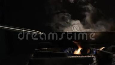 在黑暗厨房的灶台上安装带有蒸汽的大锅