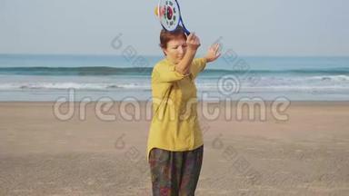 资深女士在沙滩上练习太极气球球