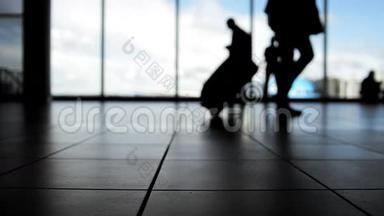 旅客<strong>在机场</strong>窗前携带行李登机，侧影