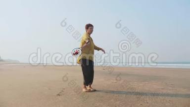 资深女士在沙滩上练习太极气球球