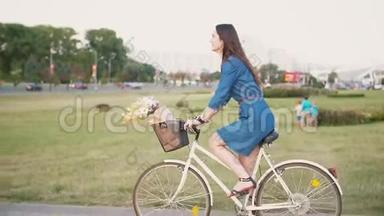 城市里一个头发长长的黑发女孩骑着一辆自行车，花篮里放着鲜花，慢悠悠地拍着的镜头