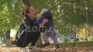 妈妈在一个秋天的公园里围着一个小儿子转。 秋天公园的<strong>幸福</strong>家庭。 慢生活中的<strong>幸福</strong>家庭