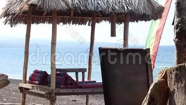 在巴厘岛浪漫的海滩上，木制的遮风避雨的<strong>凉亭</strong>。 巴厘岛以东，阿米德有黑色火山沙的海滩
