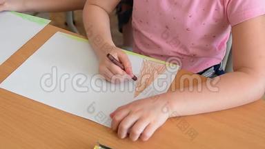孩子的手在用彩色铅笔画画。 画铅笔，孩子们学习世界，画房子，树，太阳