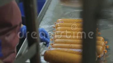一名香肠制品生产车间工人系在棍子上。