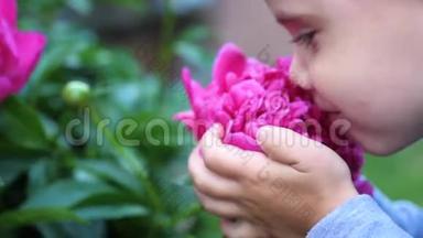 一个小可爱的宝宝轻轻地享受着花香.. 孩子拿起一朵花，吸入它的芬芳。 化名
