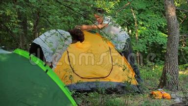 女孩和男人在落叶中搭帐篷