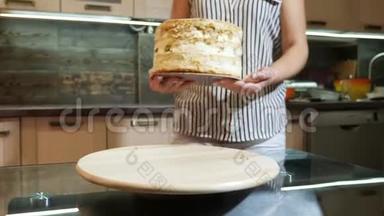 女人把蛋糕放在旋转的<strong>支架</strong>上，准备<strong>装饰</strong>蛋糕。