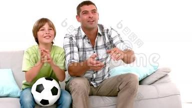 慢动作快乐的父亲和儿子一起看足球电视