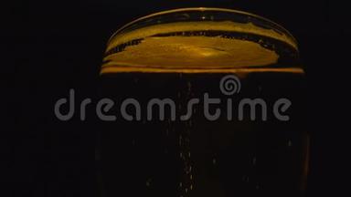 在黑色背景上隔离的玻璃中的冷光啤酒。 <strong>快来</strong>点啤酒。 旋转360度。