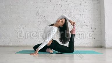 美丽的年轻女子做瑜伽运动，一条腿的鸽子王，侧视