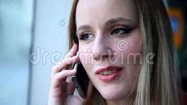 美丽的金发女人坐电车，在手机、手机、手机上说话，咬着嘴唇