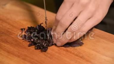 一个女孩的手特写在家厨房的一块木制砧板上小樱桃西红柿。家常菜