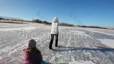 女孩在<strong>冰冻</strong>的湖面上雪橇姐姐