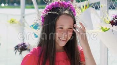 快乐的年轻女孩在手里嗅着花，在海湾酒吧微笑。 慢慢地