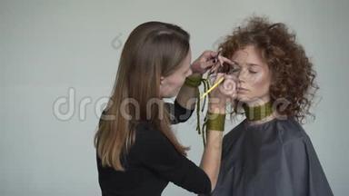 专业化妆师的特写镜头是将红色唇彩运用到模特身上。