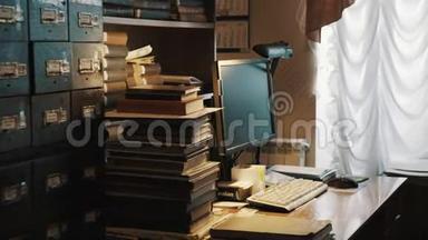 桌上摆放着方形电脑显示器，旧档案室内摆放着一堆书