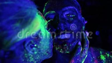 恋爱中的情侣在紫外线下涂上荧光粉亲吻。