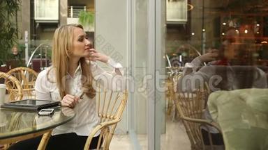 女孩在一家咖啡馆里梳头，望着窗外
