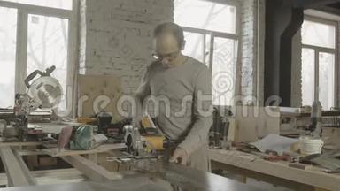 木工将圆锯固定在工作台的木板边缘