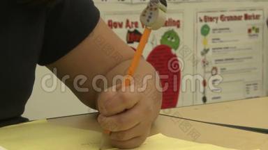 语法学校学生用铅笔在课堂上写作（2分之一）