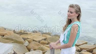 夏天穿着白色工作服的漂亮年轻女人站在木墩上。