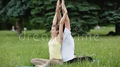 一个男人和一个女人在做运动之前伸展身体。 年轻的瑜伽教练在绿草如茵的城市公园练习