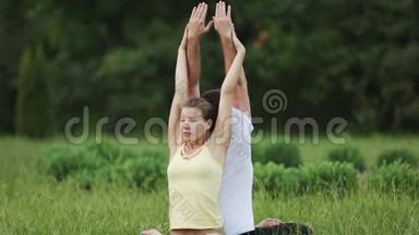 一个男人和一个<strong>女人在做</strong>运动之前伸展身体。 年轻的<strong>瑜伽</strong>教练<strong>在</strong>绿草如茵的城市公园练习