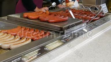 一位女售货员在烤架上烤香肠，布拉格市中心的街头食品，还有各种不同的香肠。
