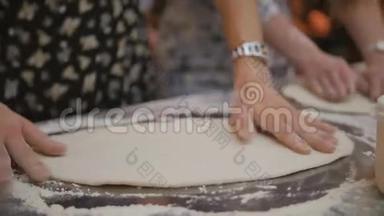 女人用手捏着装满面粉的金属桌子上的面团