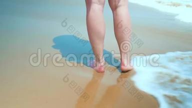 腿脚白种人女孩赤脚走湿沙岛海滩。 动作缓慢。 近距离射击。