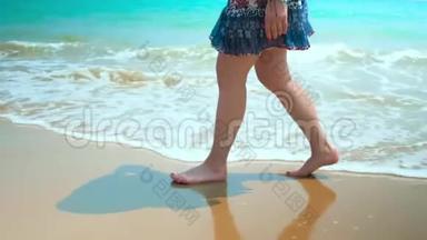 腿脚白种人女孩赤脚走湿沙岛海滩。 动作缓慢。 近距离射击。