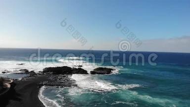 大西洋波浪在山的背景和日落在特内里费岛。 金丝雀群岛和美丽的自然。 一堆石头