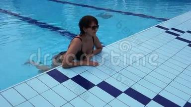 迷人的女人在游泳池里放松