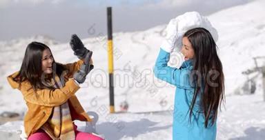 两个年轻的女朋友在雪地里玩耍