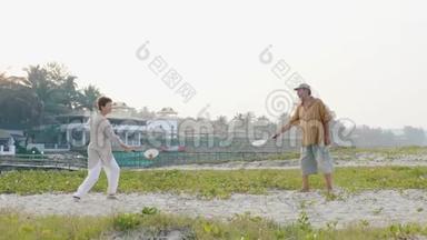 活跃的老夫妇在海滩上缓慢地打太极球。