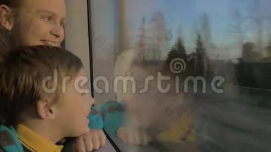 小男孩和妈妈坐在<strong>火车车厢</strong>里的靠窗的地方看着外面