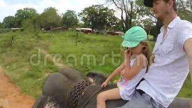 可爱的金发女孩和她的父亲在斯里兰卡骑大象。