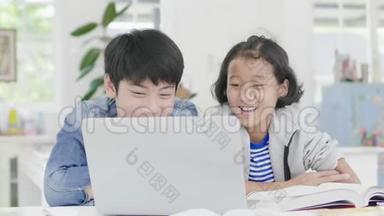 小男孩正在用电脑教和解释家庭作业。 给有<strong>表情</strong>和快乐<strong>手势</strong>的朋友，