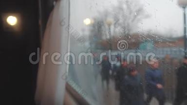 从火车车窗上看，车窗上的雨。 人们沿着铁路走。 火车铁路