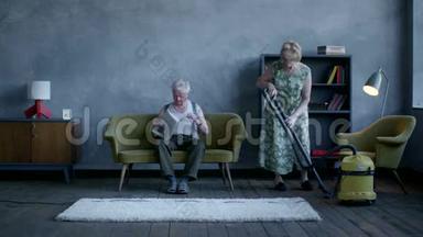 一位老年妇女正在打扫地板，一位老年男子正在看报纸和电视