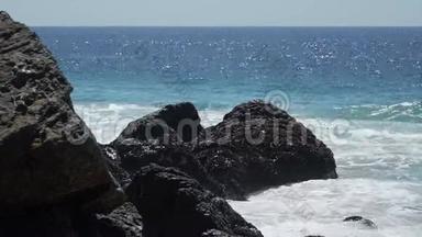 在Dume角阳光明媚的一天，海浪撞击岩石的景象