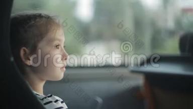 一个小女孩坐在窗边的公共汽车上